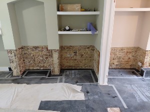 DPC installation during rising damp treatment in Raynes Park