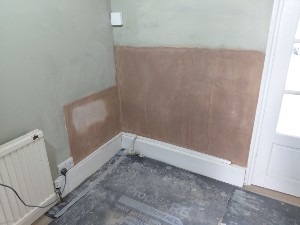 Replastered wall following damp proof course treatment in Raynes Park